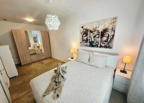 a bedroom with a bed and a chandelier at Bungalow Alma Playa Roca in Costa Teguise