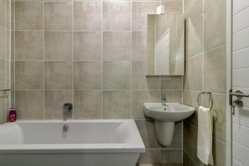 a bathroom with a bath tub and a sink at The Greenlee Grove in Sandton