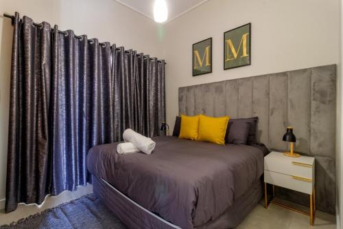a bedroom with a large bed with blue and yellow pillows at The Greenlee Grove in Sandton