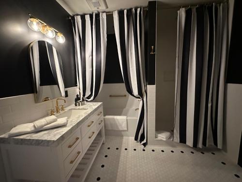 a black and white bathroom with a shower and a sink at The Boardwalk Hotel in Saint Ignace