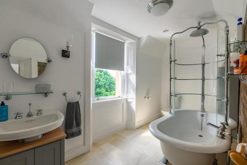a bathroom with a tub and a sink and a mirror at Drumnacree House, Alyth in Alyth