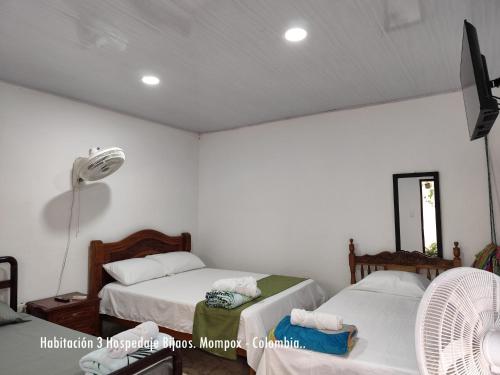 a bedroom with two beds and a fan at Casa Hotel Bijaos in Mompós