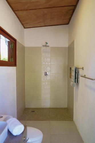 a bathroom with a shower with a toilet and a sink at Echoes Surf Casitas in Mechapa