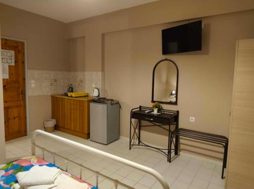 a room with a bed and a table and a television at Alexia Ferentinou in Fiskardo
