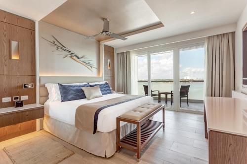 a bedroom with a bed and a view of the water at Royalton CHIC Cancun, An Autograph Collection All-Inclusive Resort - Adults Only in Cancún