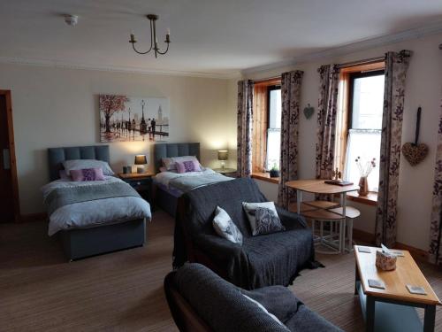 a living room with two beds and a couch at Bellevue Inn in Saint Margarets Hope