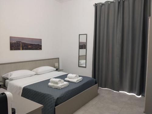 a bedroom with a bed with towels on it at Carolina's Bedrooms in Trapani