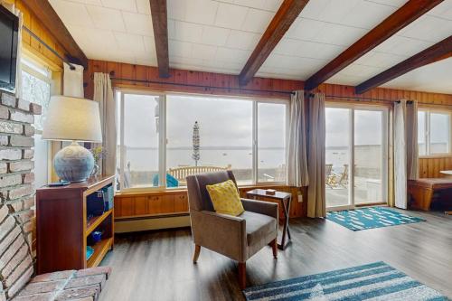 a living room with a chair and a large window at Oceanfront Beauty in Blaine