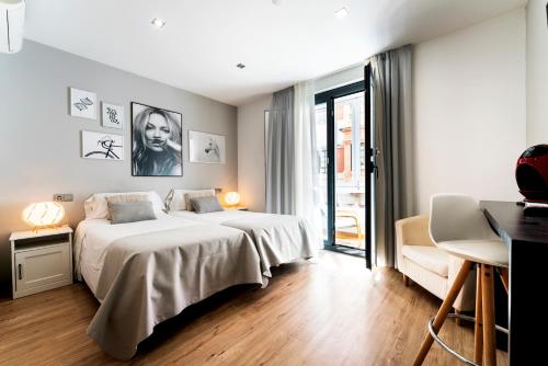a bedroom with a large white bed and a desk at Infinium Zamora Suites con parking in Zamora