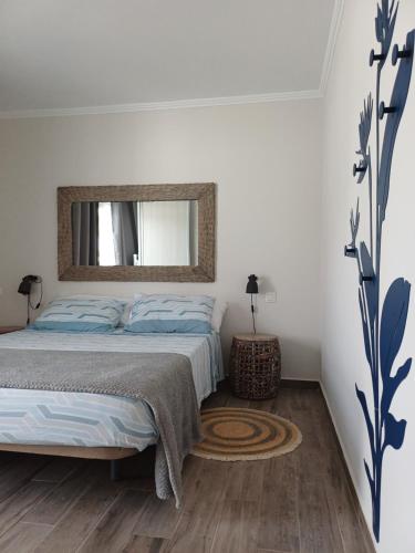 a bedroom with a bed with a mirror on the wall at Casa Esterlita in Tarajalejo