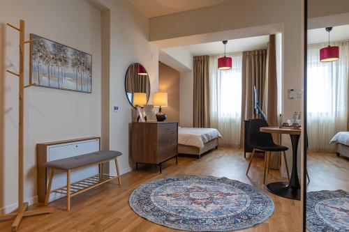 a room with a bedroom with a bed and a mirror at Habitat Suites III in Craiova