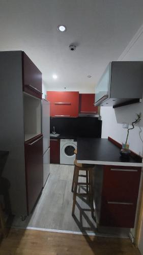 a kitchen with red cabinets and a black counter top at 1A chambre confortable 02 in Audun-le-Tiche