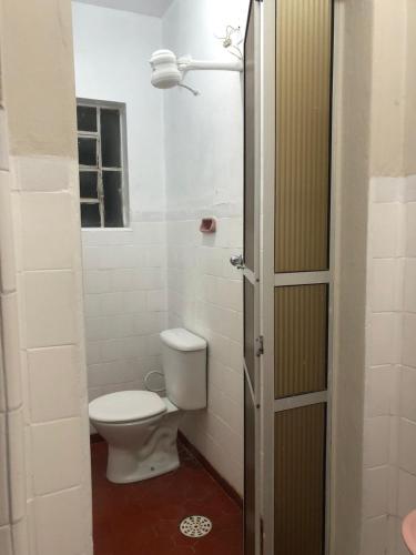 ein Badezimmer mit Toilette, Fenster und Licht in der Unterkunft Hotel Eldorado in Eldorado