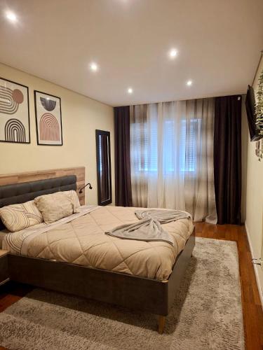 a bedroom with a bed and a large window at N3 Apartment in Amadora