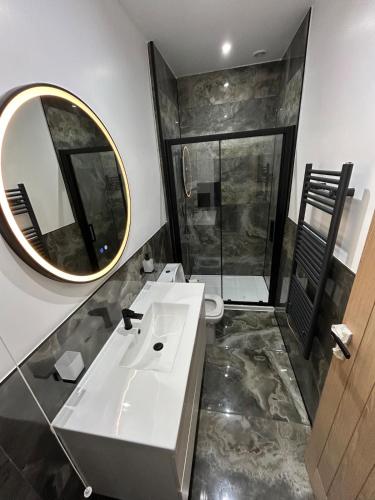 a bathroom with a white sink and a mirror at Spacious 6-Guest Retreat with Pool Table in Dinnington