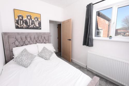 a white bed in a room with a window at Spacious 6-Guest Retreat with Pool Table in Dinnington