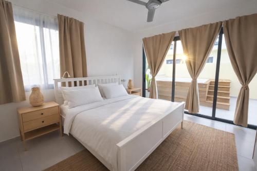 a bedroom with a white bed and a large window at Dream House Las Terrenas Terraza privada & Jacuzzi in Las Terrenas