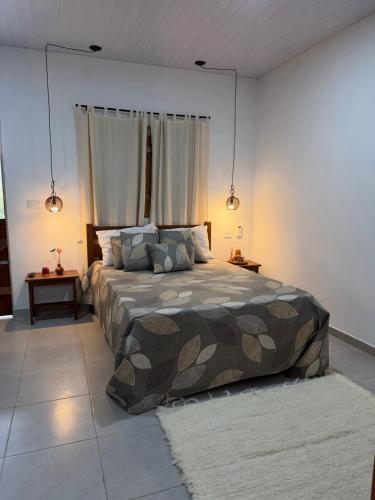 a bedroom with a bed with a camouflage blanket at Casa verde Recanto Doce lar in Gravatá