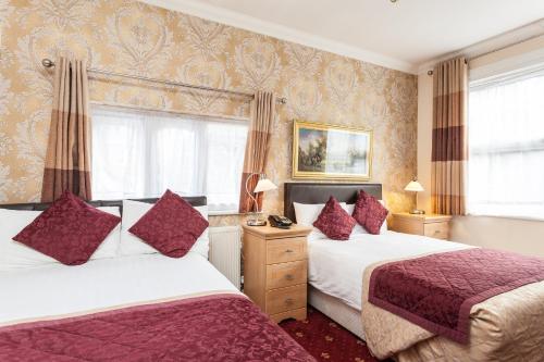 a hotel room with two beds and curtains at Roseview Alexandra Palace Hotel in London
