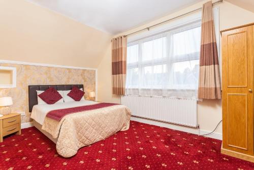 a bedroom with a bed and a large window at Roseview Alexandra Palace Hotel in London