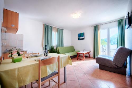a kitchen and living room with a table and chairs at Apartments Bruna in Lastovo