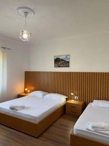 a bedroom with two beds and two lights on the wall at Villa Fjorentin Berat in Berat