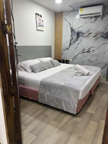 a bedroom with a bed and a rock wall at Santa Alejandría Hotel in Cartagena de Indias