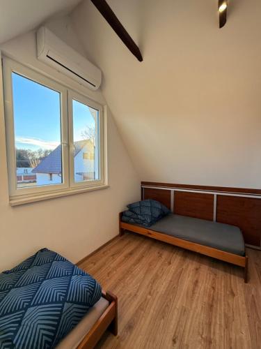 a bedroom with a bed and a window at Zakątek Lechicki Domek in Tarnów Jezierny