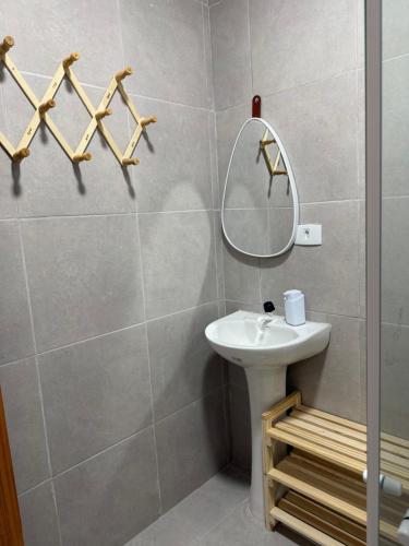 a bathroom with a sink and a mirror at Casa azul Recanto Doce Lar in Gravatá