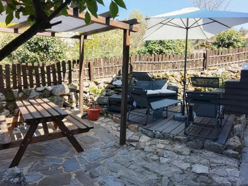 a patio with an umbrella and a table and chairs at Ninho do Corvo da Urgueira in Urgueira
