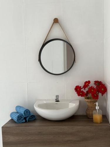 a bathroom with a sink and a mirror on the wall at Casa Laranja Recanto Doce Lar in Gravatá