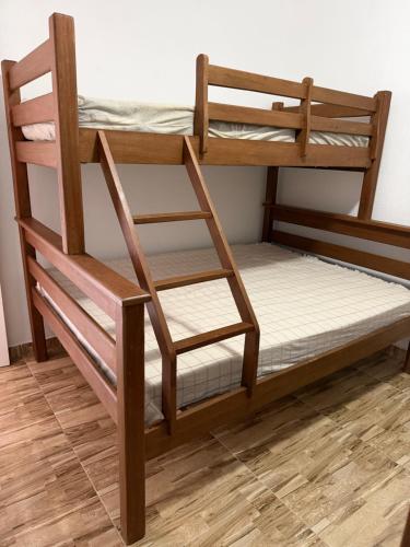 a bunk bed with a ladder and a chair at Casa Laranja Recanto Doce Lar in Gravatá