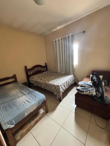 a bedroom with two beds and a fan in it at Barbosa in Três Marias