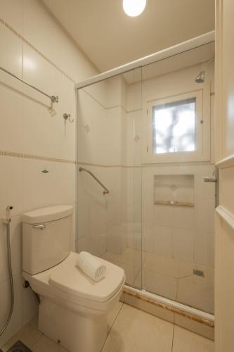 a bathroom with a toilet and a glass shower at Doce Canela - Pousada de Charme in Canela
