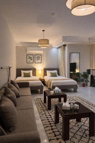 a living room with two beds and a couch at Jira Inn Hotel - چيران in Cairo