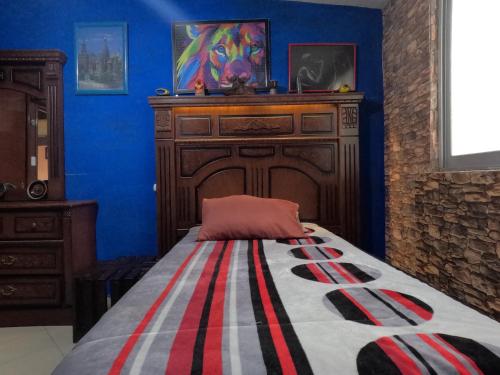 a bedroom with a bed and a wooden dresser at Cómoda habitación para descanso, La casa del artista in Toluca