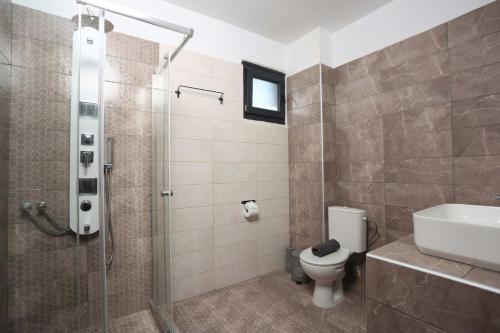 a bathroom with a shower and a toilet and a sink at Hilltop Apartment 6 in Hanioti
