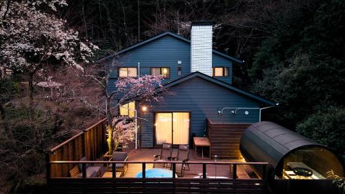 a blue house with a large pipe in front of it at Villa Noël Hakone Chimney Luxury Onsen & Sauna Retreat in Hakone