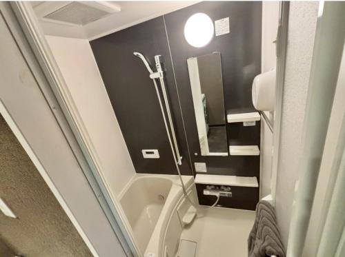 a small bathroom with a shower and a sink at HoTTOSTAY旭 in Nishi-biwajima