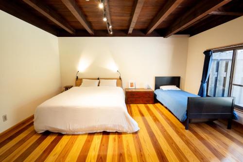 a bedroom with two beds and a desk and a chair at Asobi Lodge in Kyotango