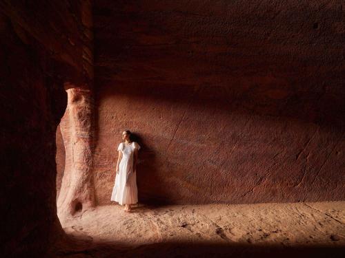 a woman in a white dress standing in a cave at Grand Mercure Petra in Wadi Musa