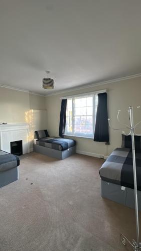 a large living room with two beds and a fireplace at Two Perfect for large groups and secured free parking in Reading