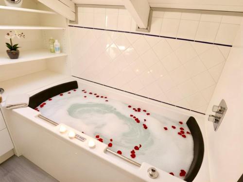 eine mit roten Herzen gefüllte Badewanne in einem Badezimmer in der Unterkunft Myrabelle in Biron