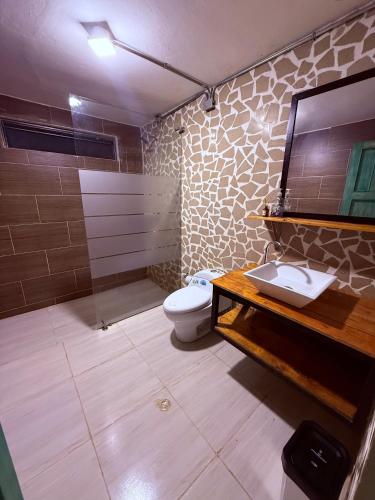 a bathroom with a toilet and a shower and a sink at Hotel TIERRA NUEVA Campestre in La Vega