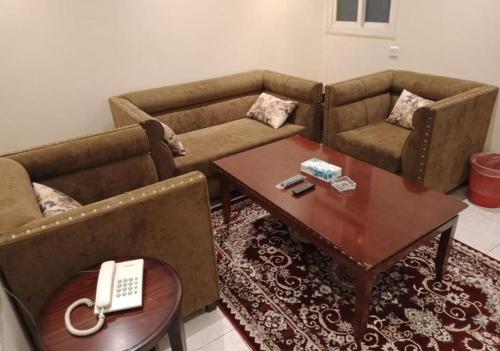 a living room with two couches and a coffee table at شقق النسيم in Quai