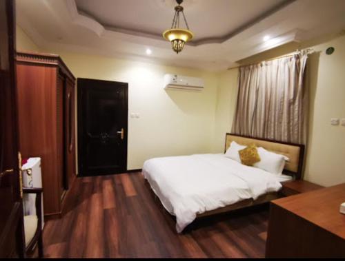 a bedroom with a white bed and a window at شقق النسيم in Quai
