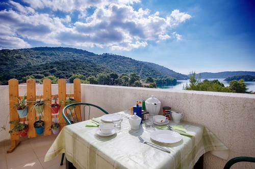 a table on a balcony with a view of a mountain at Apartments Bruna in Lastovo