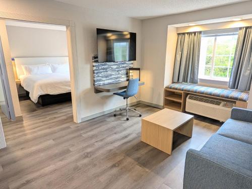 a hotel room with a bed and a desk at Greenville Pelham Inn by IHG in Greenville