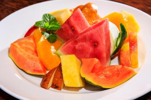 a white plate with a variety of fruits on it at Maui Palms in Korolevu