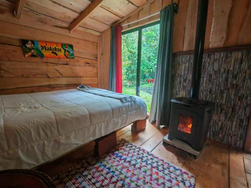 a bedroom with a bed and a wood stove at DondeLalo Hospedaje y Camping in Heredia